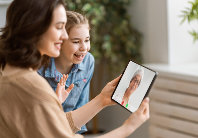 Mutter und Tochter sprechen per Videocall mit digitalem KI-Avatar einer Ärztin
